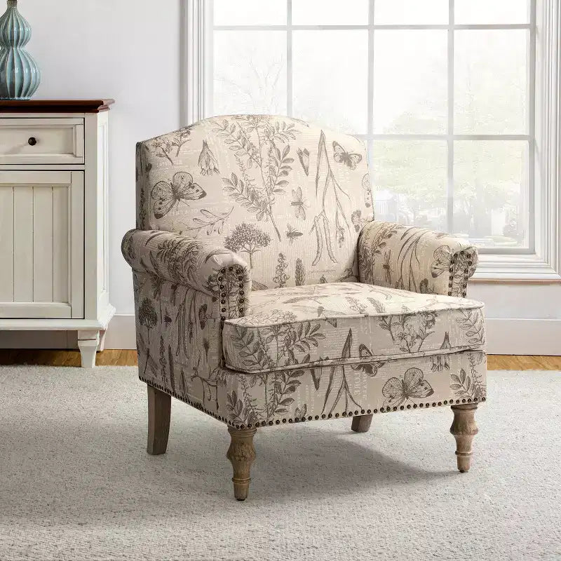 Fauteuil rembourré en bois avec motif floral, accoudoirs à panneaux et dossier en forme de bosse de chameau.